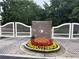 Community entrance with white gates, brick accent, and a colorful flower bed at 1935 Cobblestone Ne Cir, Brookhaven, GA 30319