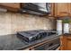 Close-up on cooktop, showcasing granite countertop and tile backsplash at 1935 Cobblestone Ne Cir, Brookhaven, GA 30319