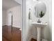 Clean half bath with pedestal sink, round mirror, and view into hallway at 1935 Cobblestone Ne Cir, Brookhaven, GA 30319