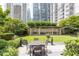 A courtyard features a table and seating, lush greenery, and benches under a trellis at 199 14Th Ne St # 412, Atlanta, GA 30309