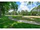 Scenic golf course view with lush green grass, mature trees, and a sand bunker on a sunny day at 2202 Lattimore Farm Nw Dr, Kennesaw, GA 30152