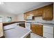 Traditional kitchen with oak cabinets, white appliances, and peninsula counter in neutral tones at 2202 Lattimore Farm Nw Dr, Kennesaw, GA 30152