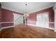 Open living room with hardwood floors, classic chandelier, and staircase access at 2202 Lattimore Farm Nw Dr, Kennesaw, GA 30152