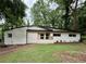 Charming single-story home with freshly painted white brick and a quaint front porch, nestled among mature trees at 2544 Overlook Dr, Atlanta, GA 30344