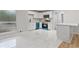 Bright kitchen with white cabinets, blue dishwasher, and marble countertops, seamlessly integrated with living area at 2544 Overlook Dr, Atlanta, GA 30344