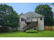 Spacious backyard featuring a deck with stairs, lush green grass, mature trees, and privacy fence at 1338 Barrett Bluff Dr, Lawrenceville, GA 30045