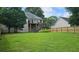 Expansive backyard with large grassy area and a wooden deck overlooking the yard with stairs at 1338 Barrett Bluff Dr, Lawrenceville, GA 30045