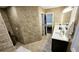 This is a renovated bathroom with marbled tile throughout and a walk-in shower with a matching sink and vanity at 1338 Barrett Bluff Dr, Lawrenceville, GA 30045