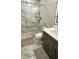 The gorgeous bathroom features a glass shower door, marble tile, and updated vanity with decorative hardware at 1338 Barrett Bluff Dr, Lawrenceville, GA 30045