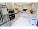 Updated kitchen with stainless steel appliances, white cabinets, and white countertops with matching tile floors at 1338 Barrett Bluff Dr, Lawrenceville, GA 30045