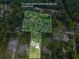 Aerial view shows approximate property lines, with a home surrounded by lush trees at 4017 S South Bogan Road Rd, Buford, GA 30519