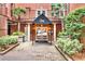 Inviting building entrance featuring well-manicured landscaping, a covered entryway, and clear signage at 211 Colonial Homes Nw Dr # 1102, Atlanta, GA 30309