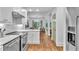 Modern white kitchen with stainless steel appliances and view of dining area at 211 Colonial Homes Nw Dr # 1102, Atlanta, GA 30309