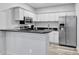 Compact kitchen featuring white cabinetry, stainless steel appliances, and breakfast bar for simple meals at 211 Colonial Homes Nw Dr # 1102, Atlanta, GA 30309