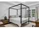 Spacious main bedroom with a four-poster bed, natural light, and decorative lamps at 211 Colonial Homes Nw Dr # 1102, Atlanta, GA 30309