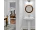 Charming powder room features stylish mirror, pedestal sink, and grey hexagon tile floor, offering a touch of elegance at 211 Colonial Homes Nw Dr # 1102, Atlanta, GA 30309