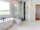 This bright main bathroom features a soaking tub by the window and a separate glass enclosed shower at 3063 Reserve Ct Sw, Conyers, GA 30094