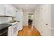 Open kitchen area with white cabinets, stainless steel appliances, hardwood floors, and a view into the dining room at 1508 Brianwood Rd # 1508, Decatur, GA 30033