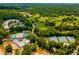Expansive aerial view showcases the tennis courts, community center, pool, and lush green golf course of the property at 229 Devonwood Dr, Atlanta, GA 30328