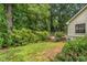A verdant backyard with grass and mature plantings offers a serene outdoor space near the home's exterior at 229 Devonwood Dr, Atlanta, GA 30328