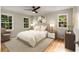 Bright bedroom featuring hardwood floors, a ceiling fan and a large bed with matching nightstands at 229 Devonwood Dr, Atlanta, GA 30328