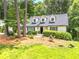 Charming home featuring a landscaped front yard with mature trees and classic dormer windows at 229 Devonwood Dr, Atlanta, GA 30328