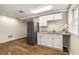 Basement kitchenette boasts white cabinets, granite countertop and stainless fridge at 229 Devonwood Dr, Atlanta, GA 30328