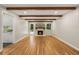 Bright living room featuring hardwood floors, exposed beams, and a brick fireplace at 229 Devonwood Dr, Atlanta, GA 30328