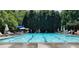 Sparkling community swimming pool with lounge chairs for relaxing in a picturesque setting with mature trees at 229 Devonwood Dr, Atlanta, GA 30328