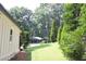 Side yard with a well-maintained lawn and mature trees at 229 Devonwood Dr, Atlanta, GA 30328