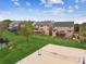 An aerial view of the grassy backyard, a volleyball court, and houses with decks in a neighborhood at 2539 Larson Creek Cv, Duluth, GA 30097