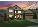 Beautiful two-story brick home with manicured lawn, colorful landscaping, and attached two-car garage at sunset at 2539 Larson Creek Cv, Duluth, GA 30097