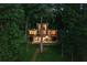 View of a modern three-story house with large windows, balconies and wooded lot at 132 Lakeshore Dr, Roswell, GA 30075