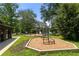 Community playground with modern climbing structure, lush lawn and view of the lake at 132 Lakeshore Dr, Roswell, GA 30075