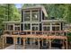 Back of house featuring expansive deck and modern design with large windows overlooking lush greenery at 132 Lakeshore Dr, Roswell, GA 30075