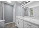 Bathroom features white vanity, updated fixtures, framed mirror and bright lighting at 2470 Hillvale Cir, Lithonia, GA 30058
