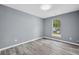 This cozy bedroom features gray walls, wood-look flooring, and a window with natural light at 2470 Hillvale Cir, Lithonia, GA 30058