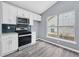 Modern kitchen with white cabinetry, stainless appliances, and a window for natural light at 2470 Hillvale Cir, Lithonia, GA 30058