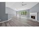Bright living room with laminate flooring, a ceiling fan, fireplace, and French doors at 2470 Hillvale Cir, Lithonia, GA 30058