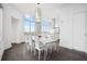Bright dining room with a modern chandelier, white dining set and expansive windows at 2828 Peachtree Nw Rd # P 3300, Atlanta, GA 30305