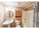 Cozy bathroom with a pedestal sink, decorative mirror, and a shower/tub combo with a patterned curtain at 1403 Benbrooke Circle Northwest Nw Cir, Acworth, GA 30101
