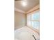 Large soaking tub surrounded by tile accents with natural light from the window at 1403 Benbrooke Circle Northwest Nw Cir, Acworth, GA 30101