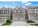 Charming brick townhome featuring a two-car garage and well-maintained landscaping at 228 Stone Park Dr, Woodstock, GA 30188