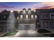 Charming brick townhome featuring a two-car garage at dusk under a colorful sky at 228 Stone Park Dr, Woodstock, GA 30188
