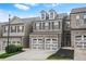 Inviting townhome featuring brick accents, two-car garage, and landscaped front yard at 228 Stone Park Dr, Woodstock, GA 30188