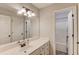 Bathroom featuring a well-lit vanity, a large mirror and a door that goes to the tub at 3072 Parks Run, Loganville, GA 30052