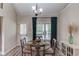 Bright dining area with a round table, four chairs, modern chandelier, large window, and easy access to the deck at 3072 Parks Run, Loganville, GA 30052