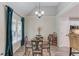 Cozy dining area with a round table, four chairs, modern chandelier, and large windows with elegant blue curtains at 3072 Parks Run, Loganville, GA 30052