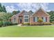Charming brick home featuring manicured lawn and mature landscaping at 3072 Parks Run, Loganville, GA 30052