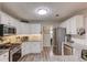 Bright kitchen featuring white cabinets, stainless steel appliances, granite countertops, and wood-look flooring at 3072 Parks Run, Loganville, GA 30052